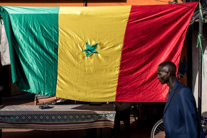 A man walks past a Senegalese flag ahead of opposition leader Ousmane Sonko and Bassirou Diomaye Faye's campaign event in Cap Skirring, Senegal on on March 16.