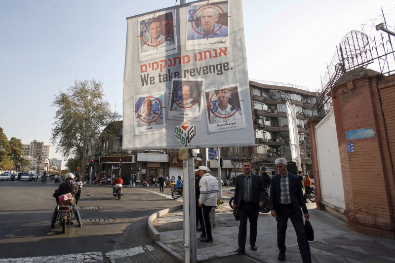 A banner displaying pictures of Israeli army officials with their faces crossed out hangs in Tehran.