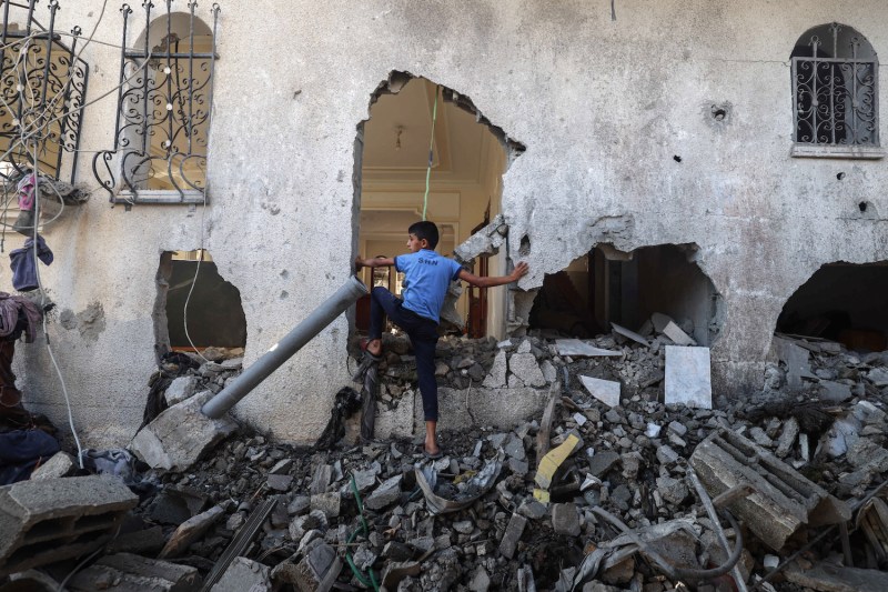 A Palestinian boy enters a destroyed building in Rafah.