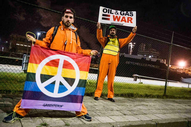 Greenpeace activists pose with placards as they stage a protest seeking to block the oil tanker "Seychelles Pioneer," reportedly carrying Russian oil, in the Port of Antwerp on April 10, 2022, amid the Russian invasion of Ukraine.