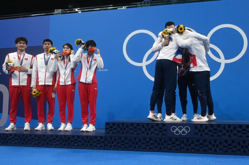China’s silver medalists, Xu Jiayu, Yan Zibei, Zhang Yufei, and Yang Junxuan, stand on the podium next to the British gold medalists after the final of the mixed 4x100m medley relay swimming event during the Olympic Games in Tokyo.