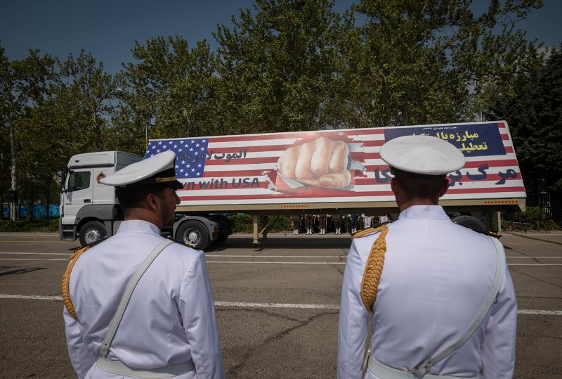 Two members of the Iranian navy stand at attention as a truck carries a massive anti-U.S. billboard during a military parade in Tehran, Iran.