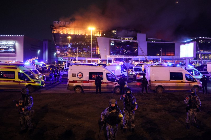 Law enforcement officers are seen deployed outside the burning Crocus City Hall concert hall following the shooting incident in Krasnogorsk, outside Moscow, on March 22.