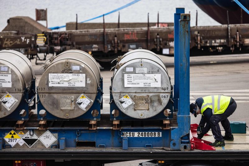 A worker secures cylinders of Russian enriched uranium on a truck following its arrival at the port of Dunkirk, France on March 20, 2023.