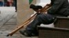 Russia -- A woman walks past a man siiting on stairs with his crutches near Red Square in Moscow, April 28, 2014