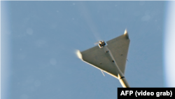 A kamikaze drone alleged to be an Iranian-made Shahed is seen in the sky over Kyiv during a strike.
