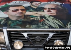 Портреты Владимира Путина и Башара Асада на капоте автомашины в Сирии