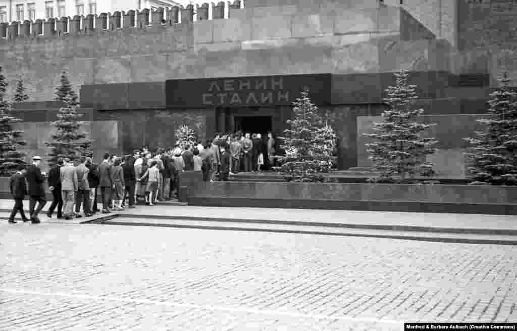 Посетители заходят в мавзолей Ленина и Сталина, август 1957 года После смерти Иосифа Сталина в 1953 году его тело забальзамировали и разместили рядом с телом Ленина. Над входом в мавзолей появилась вывеска с фамилиями двух советских диктаторов &nbsp;
