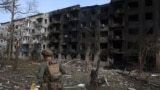 Un ofițer de poliție ucrainean lângă o clădire rezidențială distrusă în urma raidurilor aeriene rusești în satul Ocheretyne, lângă orașul Avdiivka, în regiunea Donețk, 15 aprilie 2024.