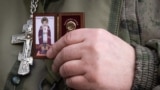 Российский полковой священник с иконой в руке в зоне боевых действий