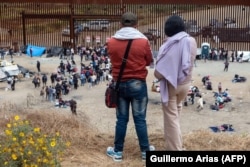 Мигранты на границе ждут, пока их документы обработают власти США. Вид со стороны города Тихуана, мексиканский штат Нижняя Калифорния