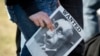 Плакат с карикатурой на Владимира Путина в руке участницы акции протеста против агрессии в отношении Украины. Берлин, лето 2022 года