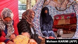 اعضای یک خانواده زلزله زده در هرات که زیر خیمه زنده گی می کنند