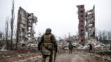 Руски войници се приближават до разрушен жилищен блок в <strong>Авдиивка</strong>, Донецка област в Украйна.<br />
<br />
Тази снимка от 22 февруари е един от първите кадри от града след превземането му от руските сили.