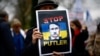 Мужчина на акции протеста с изображением Владимира Путина в виде Адольфа Гитлера возле посольства России во Франции. Париж, 17 марта 2024 года
