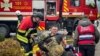Рятувальники надають допомогу постраждалому колезі на місці російського ракетного удару під час атаки Росії на Одесу 15 березня 2024 року