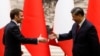 Chinese President Xi Jinping (right) and French President Emmanuel Macron shake hands at the Great Hall of the People in Beijing on April 6, 2023.