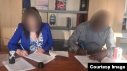 Эльнура Суранова подписывает документы с вкладчиком кооператива. 