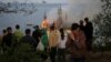 People watch as the building of an educational institution burns after a Russian missile strike on Odesa on April 29.