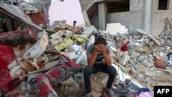 Палестинский юноша на развалинах разрушенного дома после израильского удара по городу Рафах на юге сектора Газа. 15 октября 2023 года