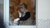 Женщина убирает осколки после очередного обстрела Киева 30 мая
