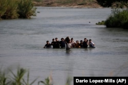 Группа нелегальных мигрантов, в основном из Никарагуа, пересекает реку Рио-Гранде и попадает в США. Штат Техас, 20 мая 2022 года