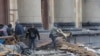 Люди расчищают завалы у Харьковской областной администрации на центральной площади