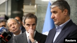 International Atomic Energy Agency (IAEA) Director-General Rafael Grossi (center) looks on during a news conference with the head of Iran's Atomic Energy Organization, Mohammad Eslami, as they meet in Tehran in March 2022. 