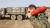 Военнослужащий "народной милиции" "ЛНР "держит агитационный снаряд, которым ведется стрельба из самоходных гаубиц "Гвоздика"