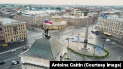 Руфер Никита Агапов устанавливает российский флаг на крыше