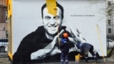 Рабочий закрашивает мурал с Навальным. 