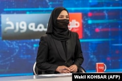 A female presenter for Tolo News covers her face in a live broadcast in May 2022.