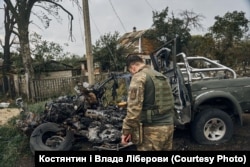 Вернополье, украинский военный смотрит на автомобиль, в котором при российском обстреле погиб его сослуживец. Фото Влады и Константина Либеровых