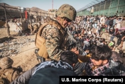 Американский морпех проверяет документы на так называемом "эвакуационном блокпосту" в аэропорту Кабула. 26 августа 2021 года