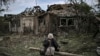Пожилая женщина сидит рядом с разрушенными в Дружковке 5 июня домами. Город Дружковка расположен в 32 километрах к югу от Славянска, где российские войска продолжают наступление с целью оккупации всего Донбасса