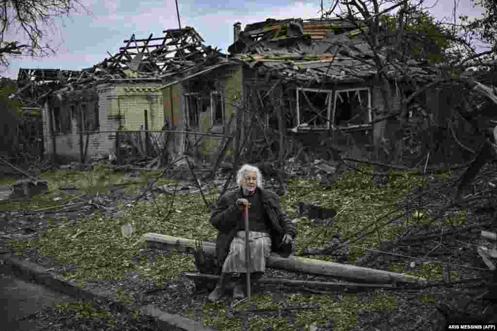 Пожилая женщина сидит рядом с разрушенными в Дружковке 5 июня домами. Город Дружковка расположен в 32 километрах к югу от Славянска, где российские войска продолжают наступление с целью оккупации всего Донбасса