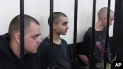 Иностранные военнослужащие ВСУ во время судебного процесса в "ДНР" – британцы Шон Пиннер и Эйден Аслин, а также марокканец Саадун Брагим (посередине)