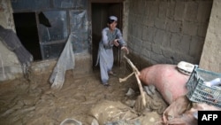 An Afghan man removes debris from his house following heavy rains and flash flooding in Kandahar on April 14.