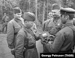 Писатели: Михаил Шолохов (на первом плане слева), Евгений Петров и Александр Фадеев (на втором плане слева направо) осматривают приборы, снятые с подбитого фашистского танка, 1941 год