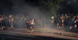 Протестующие убегают от слезоточивого газа через дорогу от Белого дома. Парковая полиция расчищала территорию перед выходом Дональда Трампа