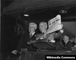 Гарри Трумэн позирует журналистам с номером Chicago Tribune в руках