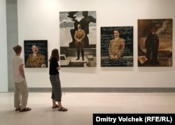 Посетители в зале, где выставлены портреты Гитлера