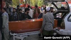 Relatives load the coffin of a victim of twin suicide bombs that killed scores of people outside Kabul airport in August 2021. The attack was claimed by the Islamic State-Khorasan militant group. 