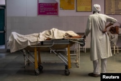 Мужчина с телом умершей от коронавируса супруги. Биджнор, 11 мая