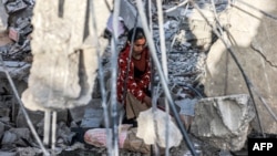 O fată adună lucruri ce mai pot fi folosite din ruine la Rafah, în sudul Fâșiei Gaza. Orașul unde s-au refugiat cam un milion de palestinieni din alte părți ale enclavei a fost cea mai recentă țintă a bombardamentelor cu care Israelul vrea să „distrugă” gruparea Hamas. 