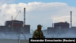 Российский военнослужащий на фоне Запорожской АЭС. 4 августа 2022 года