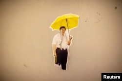 Фотоколлаж китайского лидера Си Цзиньпина с желтым зонтиком был оставлен демонстрантами на стене в гонконгском районе "Адмиралтейство" в 2014 году