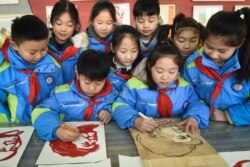 Китайские школьники вырезают из бумаги портреты Мао Цзедуна в преддверии его 127-го дня рождения. 23 декабря 2020 года