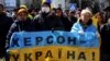 UKRAINE – People hold a Ukrainian flag with a sign that reads: "Kherson is Ukraine", during a rally against the Russian occupation in Kherson, Ukraine, 20, 2022