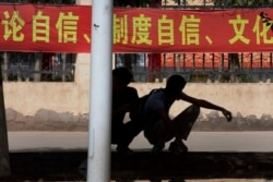 Коммунистическая символика и пропаганда окружает жителей Синьцзяна постоянно (как и всех остальных китайцев). Студенты у входа в одну из областных школ. Лозунги гласят: "Постоянный самоконтроль! Постоянный культурный контроль!"